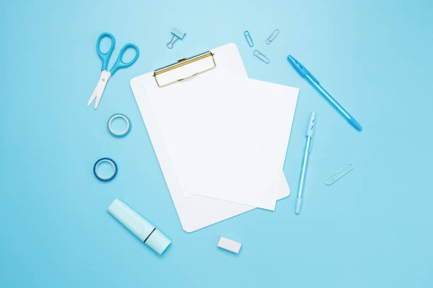 istock Creative flat lay mockup design of workspace. Top view composition with white notebook, to do list and stationery on blue background 2162526368