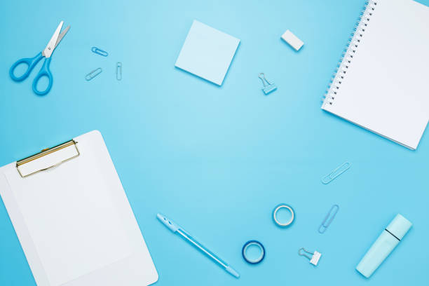 istock Creative flat lay mockup design of workspace. Top view composition with white notebook, to do list and stationery on blue background 2162526373