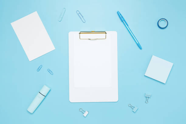 istock Creative flat lay mockup design of workspace. Top view composition with white notebook, to do list and stationery on blue background 2162526387