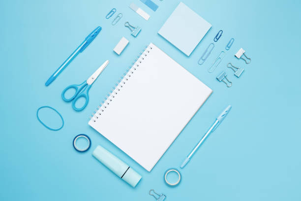 istock Creative flat lay mockup design of workspace. Top view composition with white notebook, to do list and stationery on blue background 2162526395