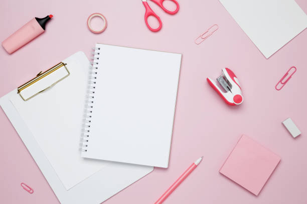 istock Creative flat lay mockup design of workspace. Top view composition with white notebook, to do list and stationery on pink background 2162526412