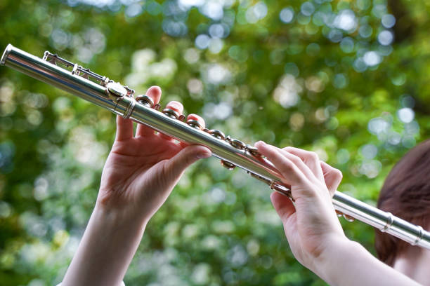 istock Hands with a flute on foliage background. Close-up 2162528217
