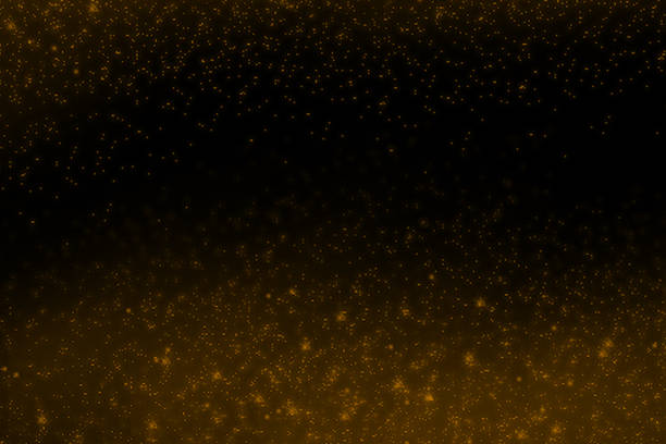 Golden flakes-glittering gold particles are scattered on the black surface.
