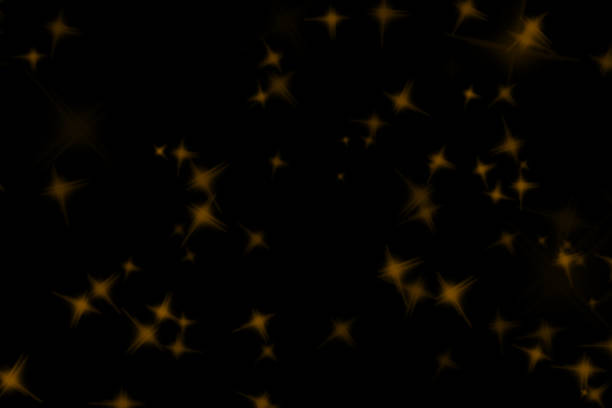 Golden flakes-glittering gold particles are scattered on the black surface.