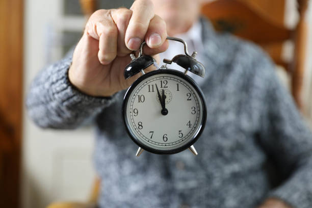 istock An elderly man holding an alarm clock. 2162530756