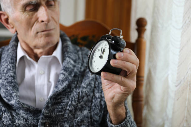 istock An elderly man holding an alarm clock. 2162530761