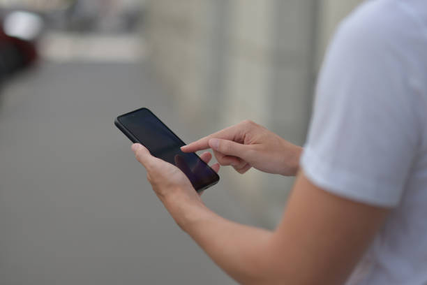 istock A man on the street using a smartphone. Mobile phone in hands close-up. 2162531370