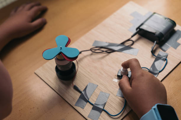 Anonymous young boy building a science project with a spinning fan. Student concentrating on building an electric circuit for his science homework