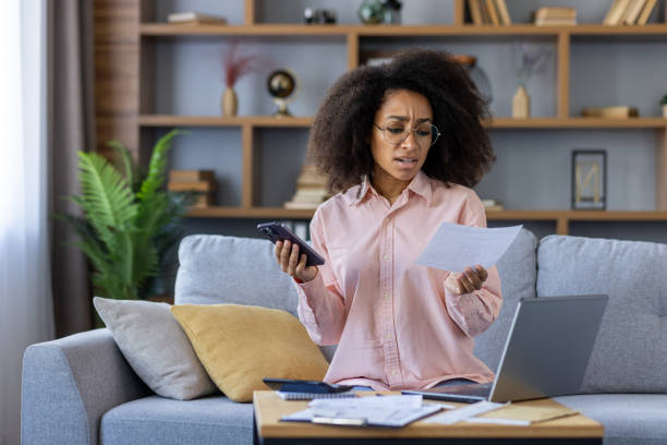 istock Stressed woman managing finances at home with smartphone and documents 2162535249