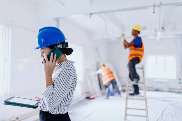 istock Side view of a smiling architect talking on a smartphone at the construction site 2162545350
