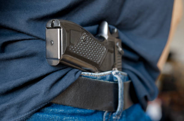 istock Black Handgun Behind Black Belt. Black gun 2162546134