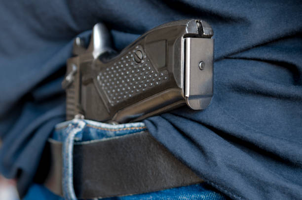 istock Black Handgun Behind Black Belt. Black gun 2162546139