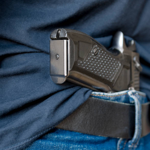 istock Black Handgun Behind Black Belt. Black gun 2162546146