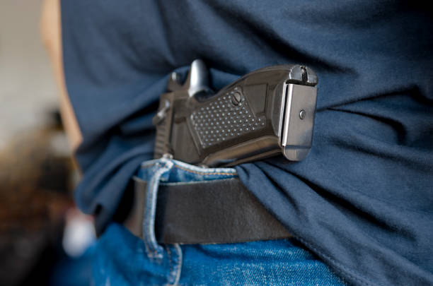 Black traumatic gun behind a black belt