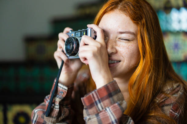 A gen z teenager using a vintage film camera