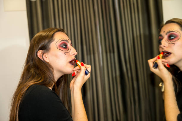 istock A woman is getting ready for a Halloween party and is putting on makeup 2162548081