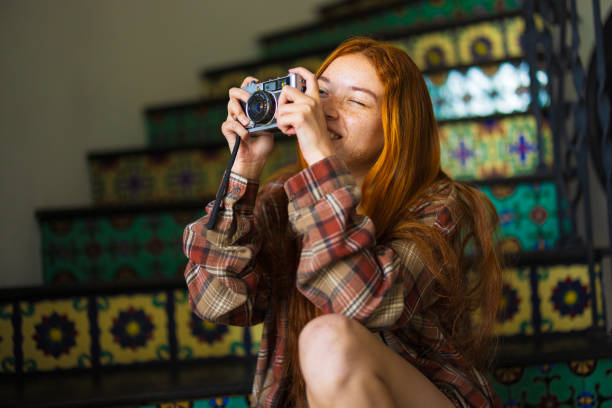 A gen z teenager using a vintage film camera