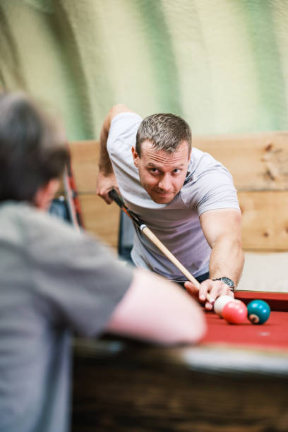 istock Two young man playing pool in man cave 2162551013