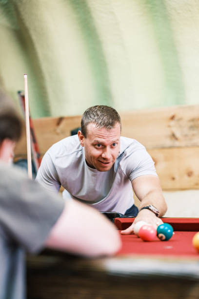 istock Two young man playing pool in man cave 2162551016