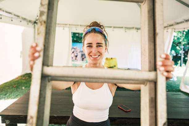istock Young woman decorating lights inside wedding reception tent 2162551180