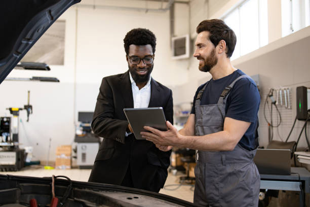 istock Business meeting between entrepreneur and auto mechanic in workshop 2162554052