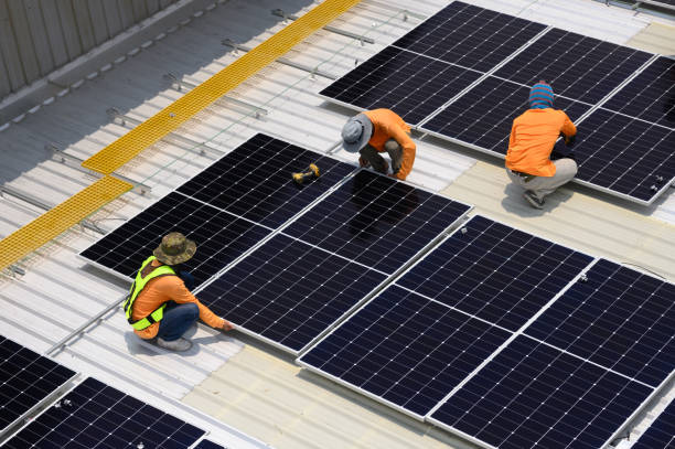 istock Worker installs solar panels. Worker installs solar panels at a solar farm field. 2162554102