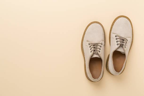 istock Beige suede shoes on color background, top view 2162555162