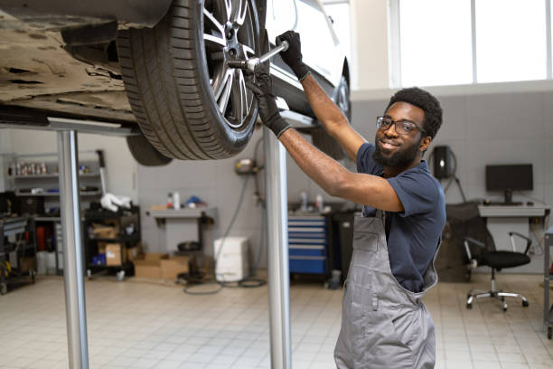 istock Smiling mechanic working on a car in a garage 2162555531