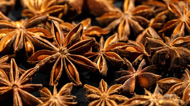 istock Brown Anise stars as pattern at sunlight, close up aromatic spices dried aniseed on black background, aesthetic food pattern, textural graphic photo, natural season condiments 2162561336