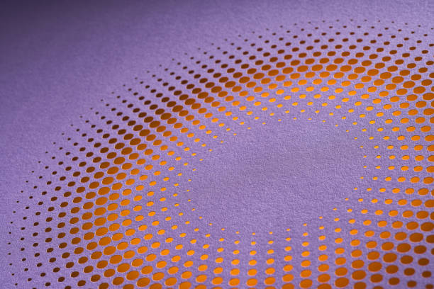 Native image size: 7952 x 5304. This still life photograph captures an abstract piece of paper art featuring intricate circular perforations arranged in a mesmerizing pattern. The design showcases a vibrant gradient transitioning from purple to orange, creating a striking visual contrast. The meticulous craftsmanship and careful attention to detail are evident in the precise alignment and uniformity of the perforations. The interplay of light and shadow further enhances the depth and texture of the artwork, making it a captivating example of modern artistic expression through the medium of cut paper.