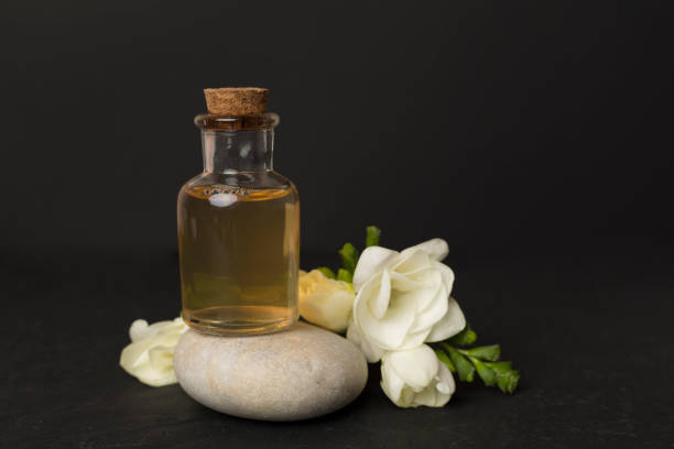 istock Glass bottleon stone with freesia flower on concrete background 2162561945