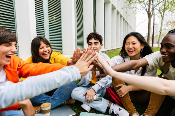 istock Happy young group of students showing support to each other joining hands 2162562279