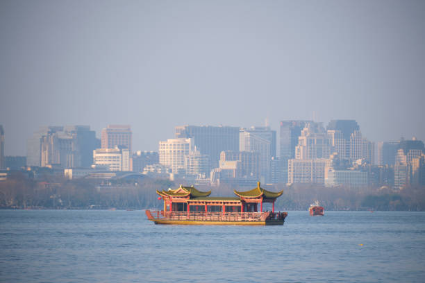 A decorative boat at Westlake with the backdrop of Hangzhou city