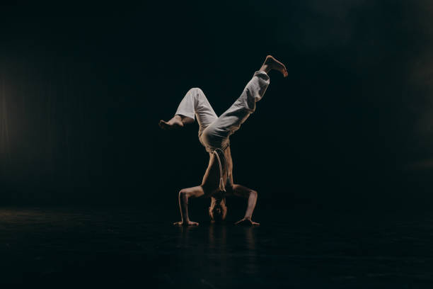 istock Male fighter training capoeira on black background 2162562559