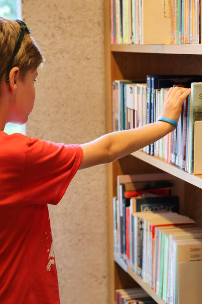 istock A boy choosing books in a library or bookstore 2162562592