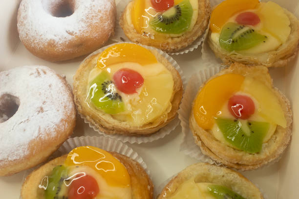istock Danish fruit tartlets and donuts in box. 2162564563
