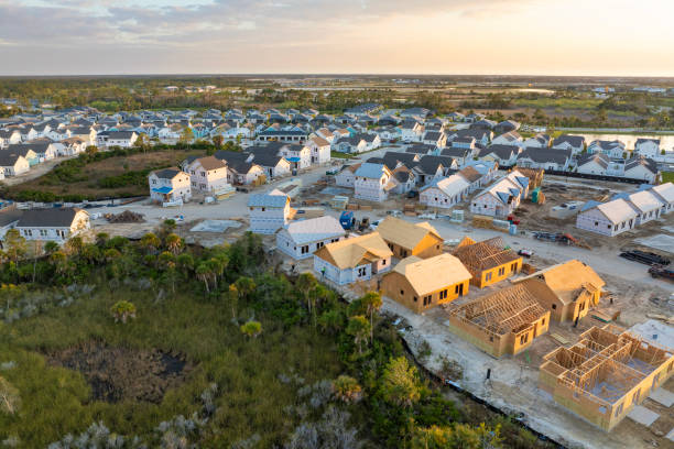Wooden houses under construction in new developing suburban area. Development of residential housing in American suburbs. Real estate market in the USA Wooden houses under construction in new developing suburban area. Development of residential housing in American suburbs. Real estate market in the USA. small florida home stock pictures, royalty-free photos & images