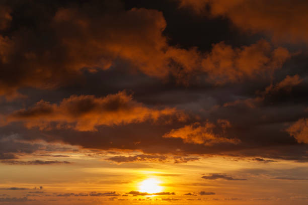 Dramatic sunset sky covered with colorful yellow clouds. Panoramic skyscape.