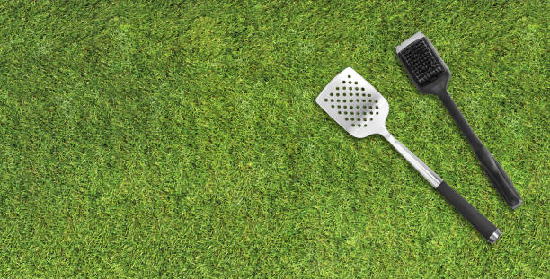istock Top view of BBQ utensils on a grass lawn 2162568383