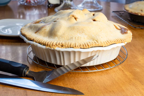 istock Making of an apple pie:  Cutting the pie.  Knife and pie server sit next to the cooled apple pie. 2162568920