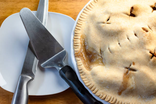 istock Making of an apple pie:  Cutting the pie.  Knife and pie server sit next to the cooled apple pie. 2162568922