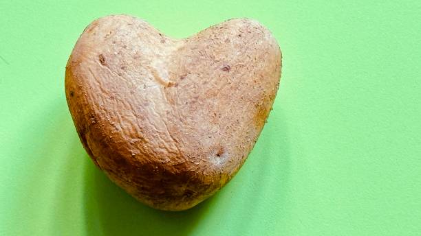 Potatoe in a heart shape on green background