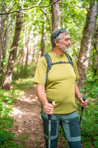 istock Elderly Man Enjoying Trekking in Green Forest 2162572911