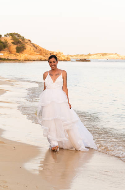 istock Bride walking on the beach with her wedding dress 2162573583