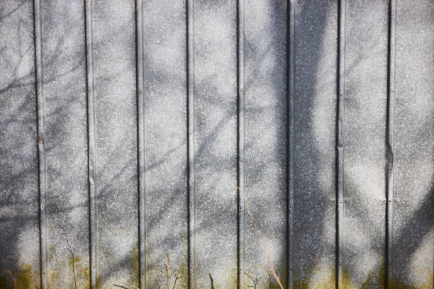 Full frame shot of metallic fence with shadow of branches during sunny day