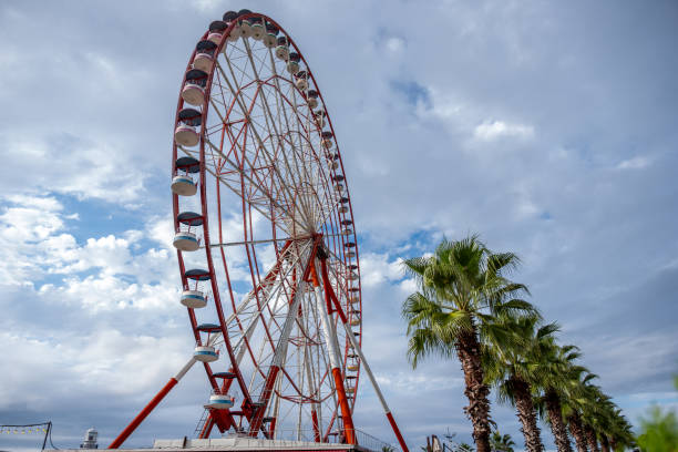 istock Red and White Ferris Wheel Against Blue and Cloudy Sky with Copy Space 2162575632