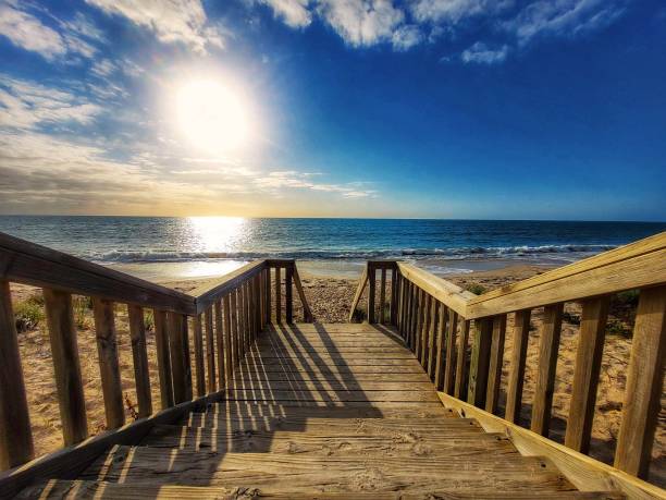 istock Wood stairs leading to sun setting beach 2162575824