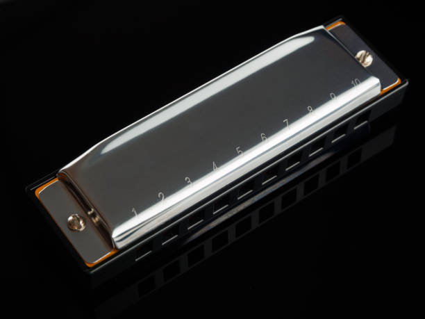 istock Close-up of a harmonica on a dark background. The instrument features a sleek and classic design with a shiny metal body and neat playing holes. Details such as engraved lettering and material texture are visible, highlighting the high quality craftsmansh 2162576754