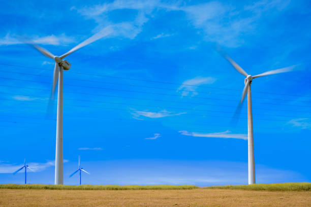 Wind turbines generating renewable energy with a clear blue sky in Tarifa, Spain. The image captures the concept of sustainable energy.