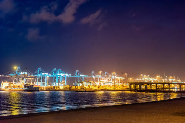 El Rinconcillo beach at night with a beautiful view of the illuminated Algeciras seaport in the background, Spain.
